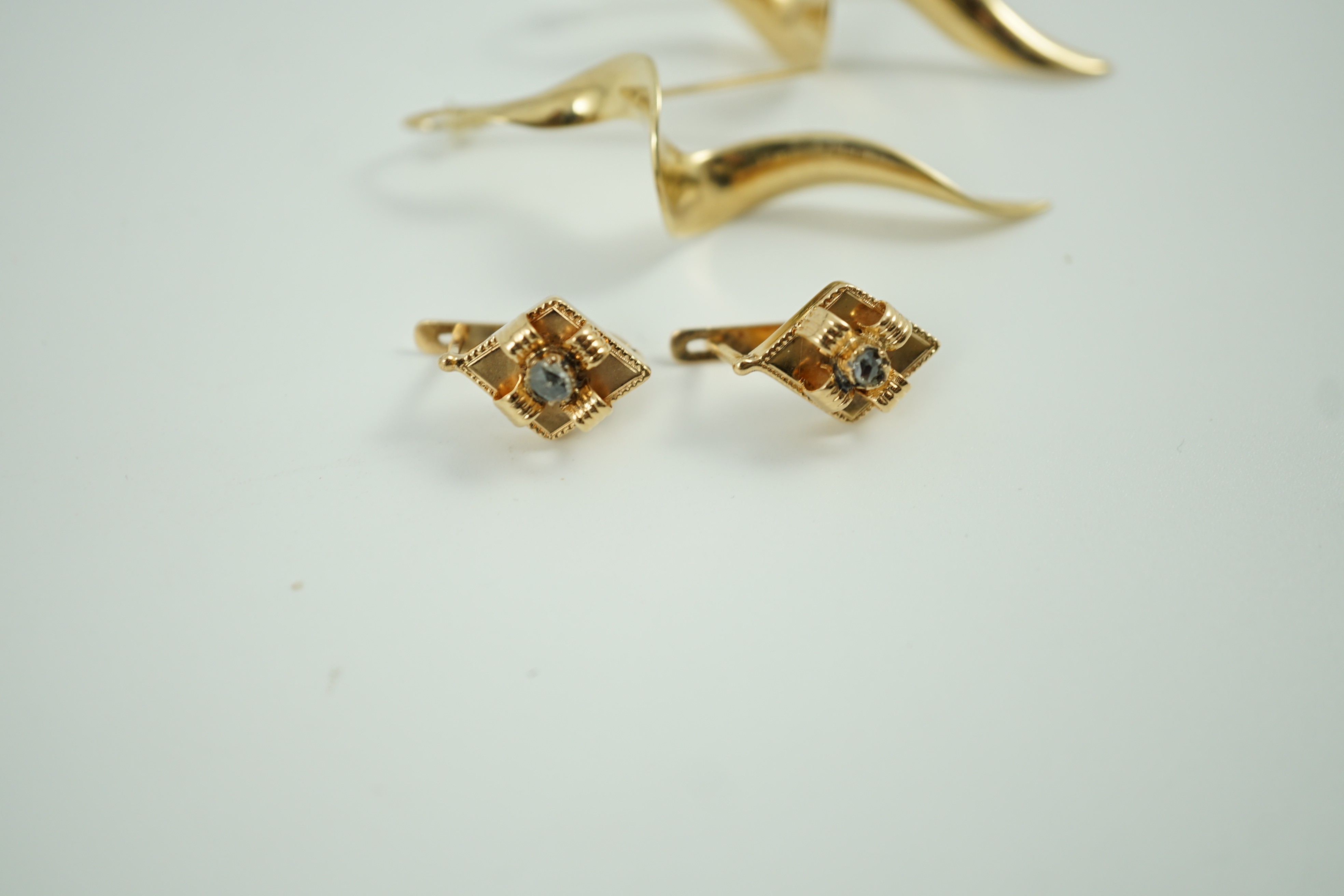 A modern pair of 14k spiral earrings, 50mm, 6.4 grams and a part of yellow metal and solitaire rose cut diamond set earrings, gross 4.2 grams.